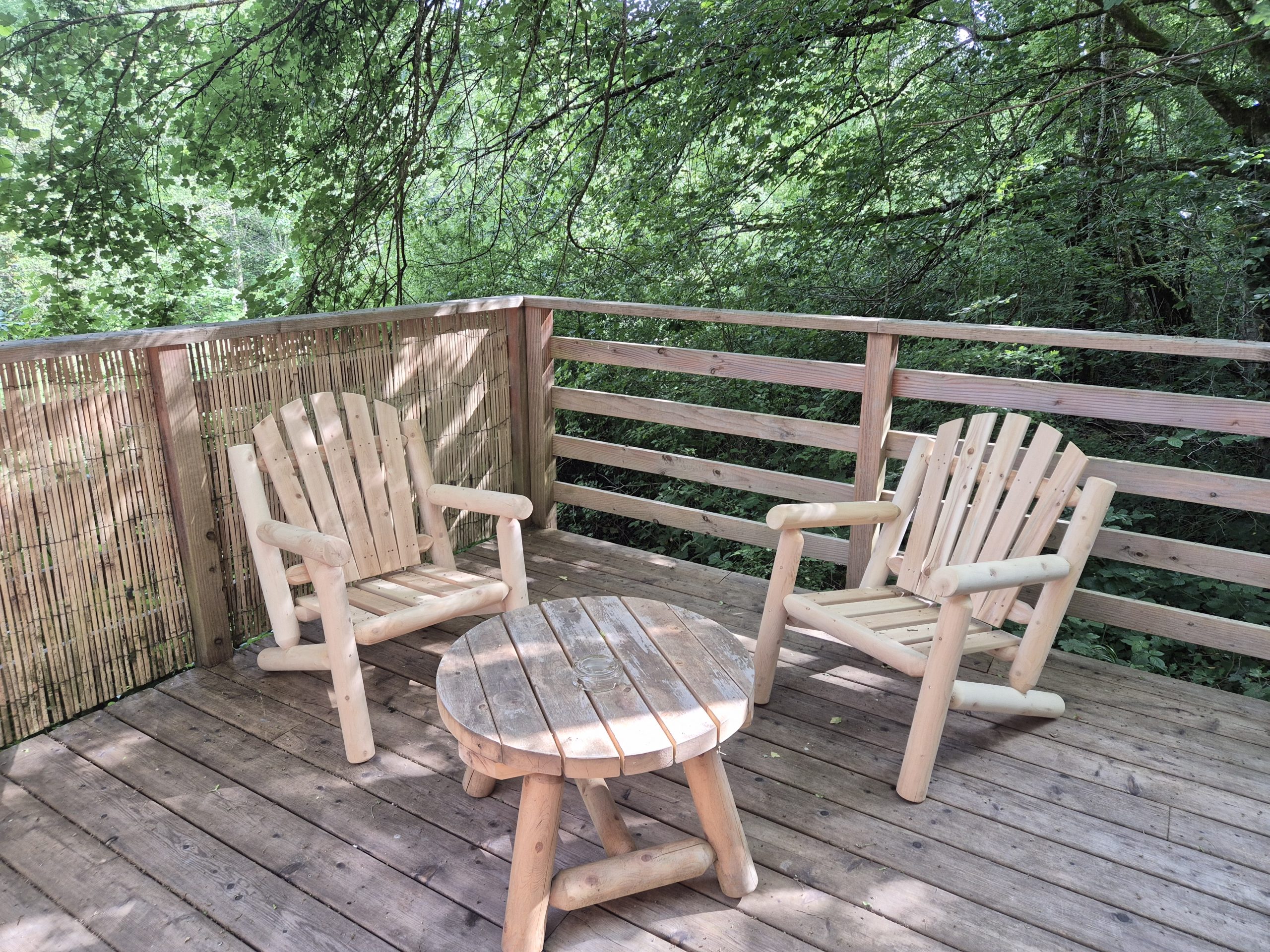 Fauteuils et table basse en cèdre au lodge Dolio au Domaine du Moulin de Trimeule